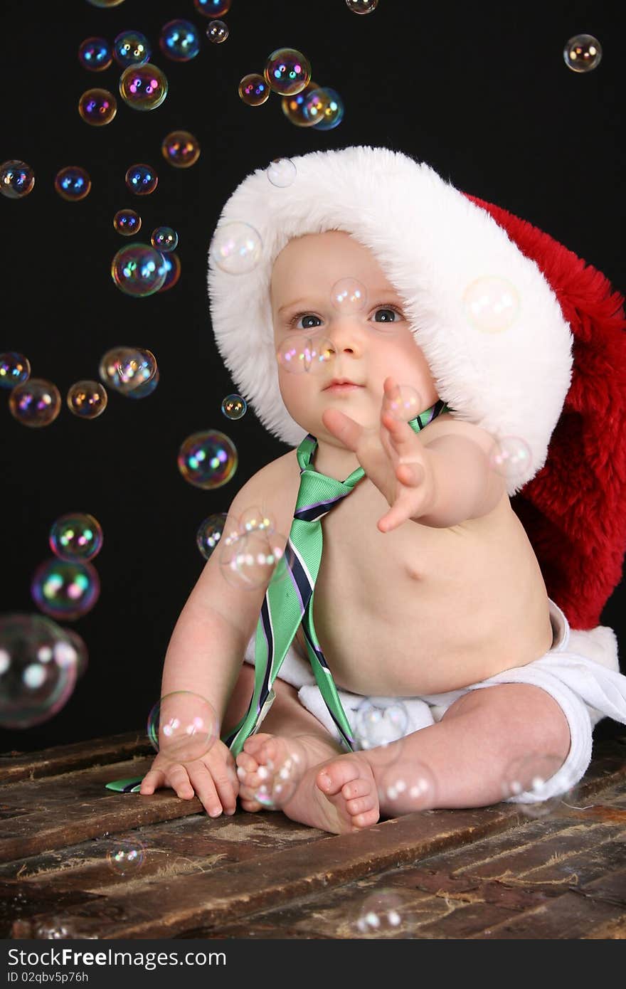 Cute christmas baby boy sitting on an antique trunk