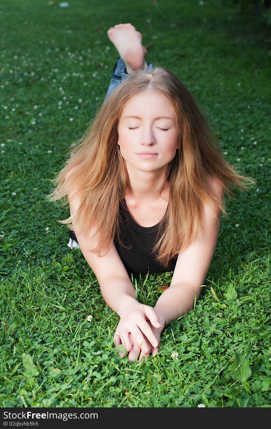 Young beautiful girl relaxing on the field (Selective focus). Young beautiful girl relaxing on the field (Selective focus)