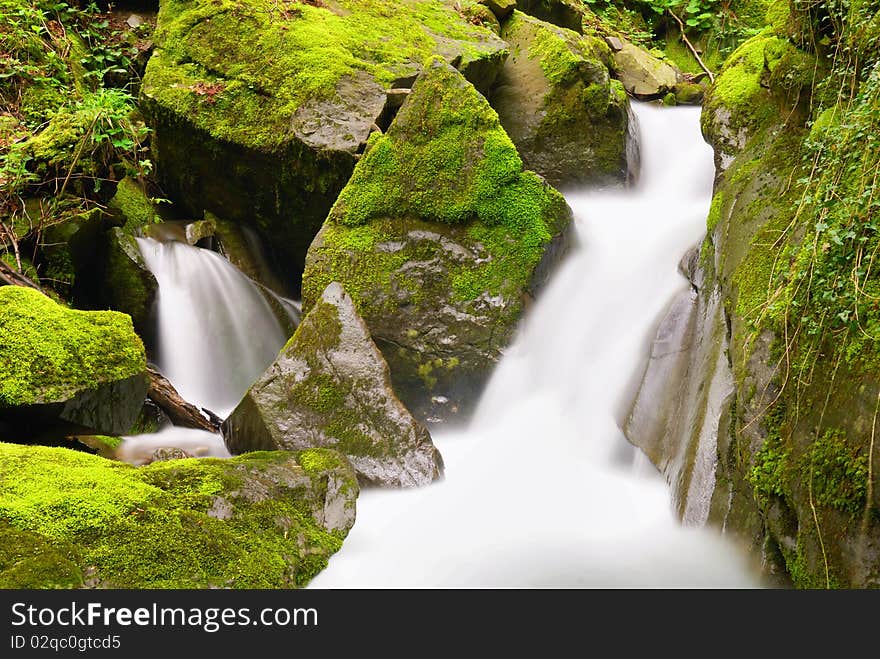 Water create a small waterfall on the rocks. Water create a small waterfall on the rocks