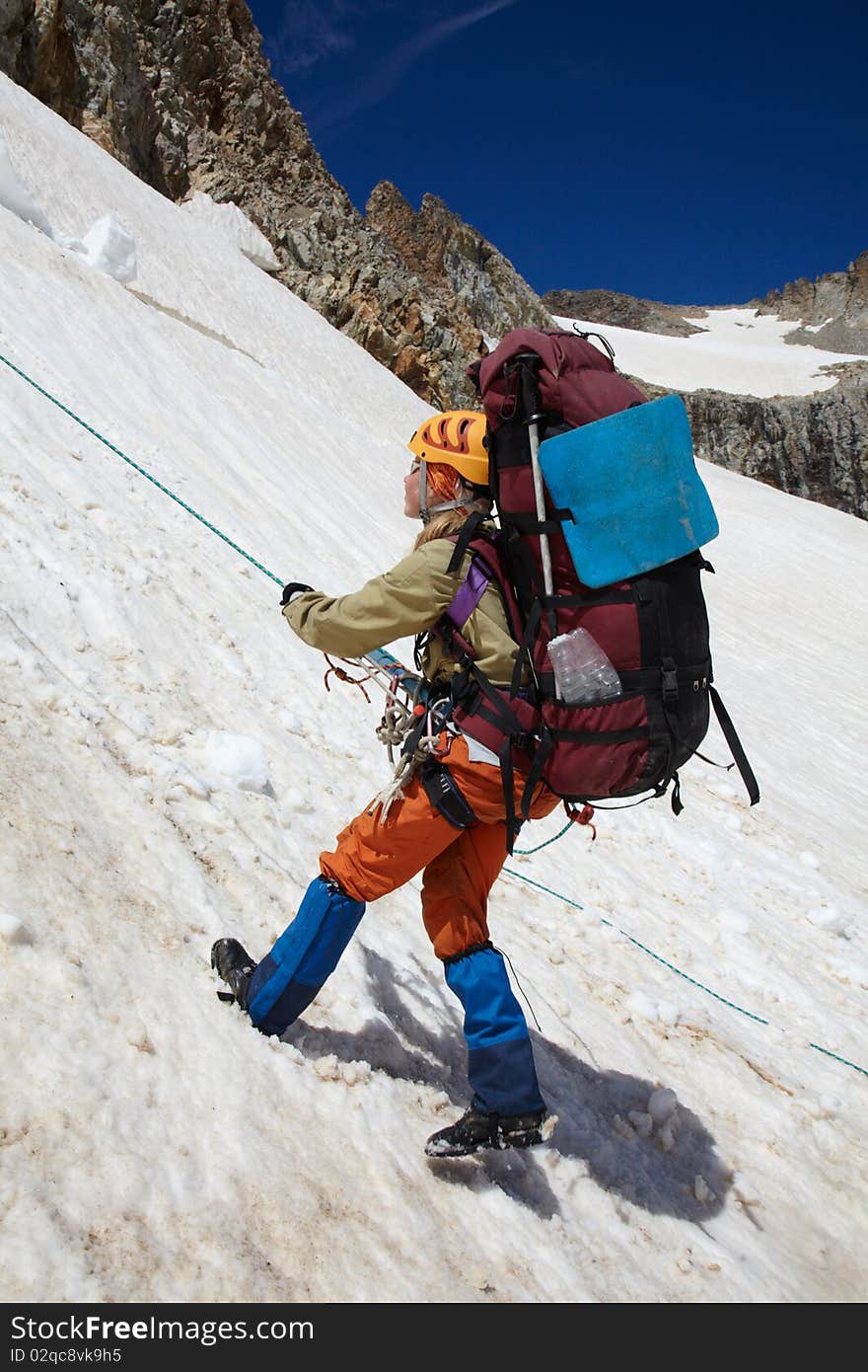 Girl moving down on snow with rope belay. Girl moving down on snow with rope belay