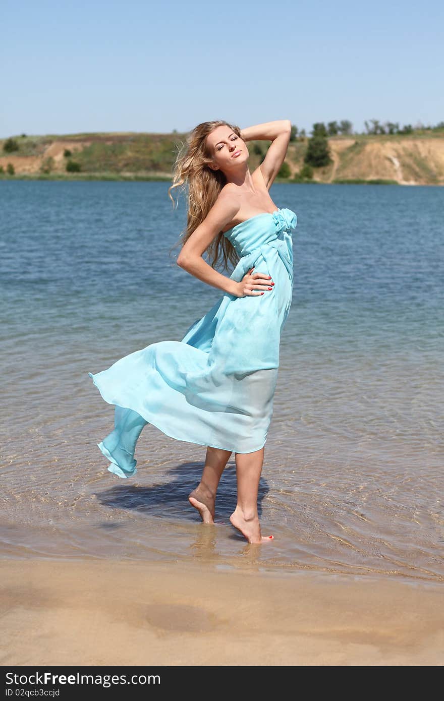 Beautiful blond girl in the sunny day on the lake