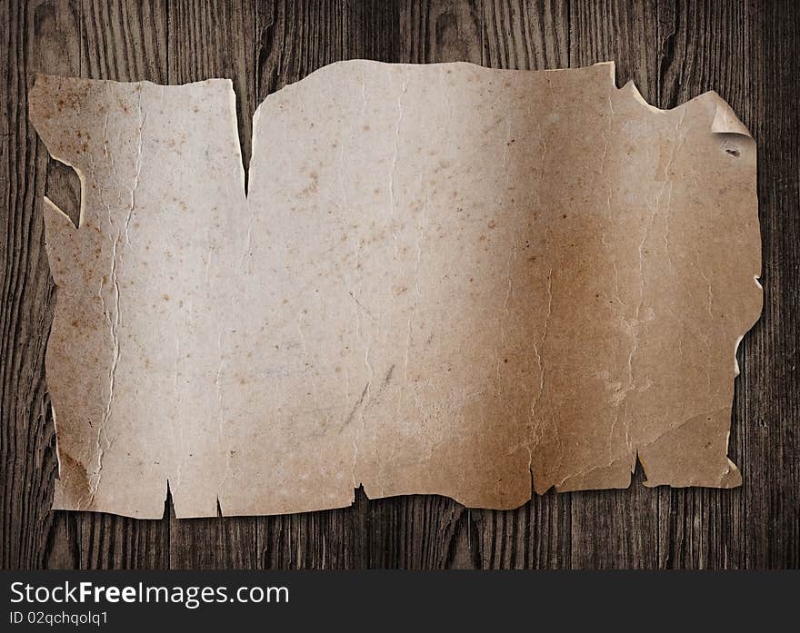 Old paper sheet on a wooden surface. Old paper sheet on a wooden surface.