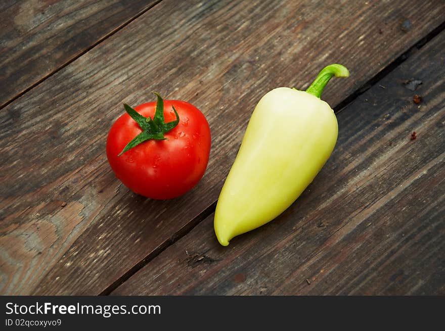 Fresh tomatoes with yellow pepper on a wooden table. Fresh tomatoes with yellow pepper on a wooden table