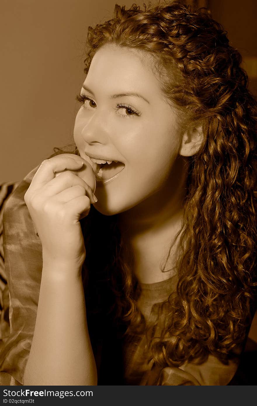 Nice young caucasian girl trying eating an apple with mouth wide open and having fun made in color corrected tonality. Nice young caucasian girl trying eating an apple with mouth wide open and having fun made in color corrected tonality