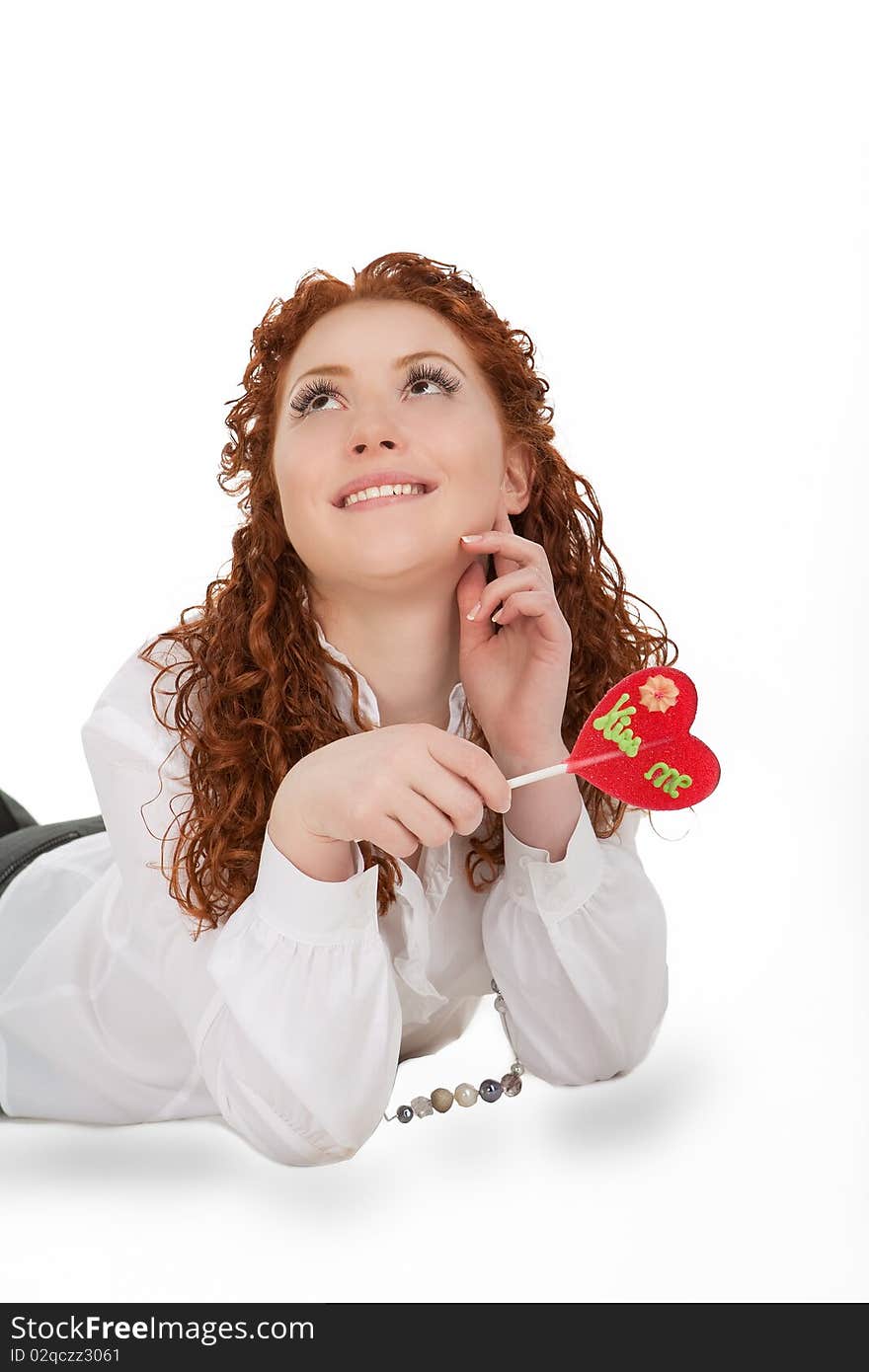 Happy positive nice caucasian girl with sincere beautiful smile lying on floor with bon-bon candy isolated on white. Happy positive nice caucasian girl with sincere beautiful smile lying on floor with bon-bon candy isolated on white