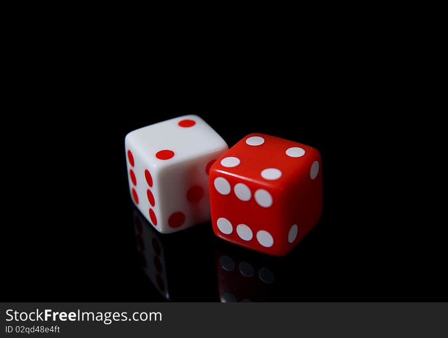 A pair of white and red dice on a black background