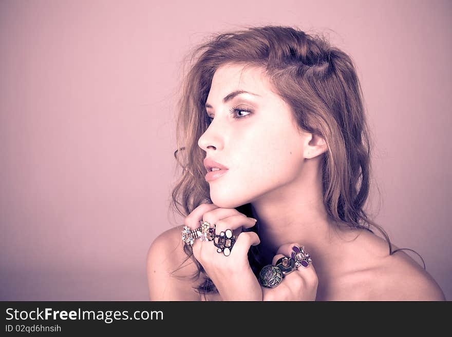 Head and shoulder portrait of a beautiful young woman wearing ornate rings on her fingers. Horizontal shot. Head and shoulder portrait of a beautiful young woman wearing ornate rings on her fingers. Horizontal shot.