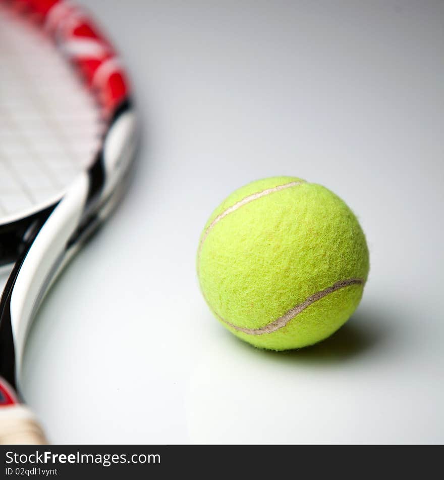 Tennis ball and racket on white background