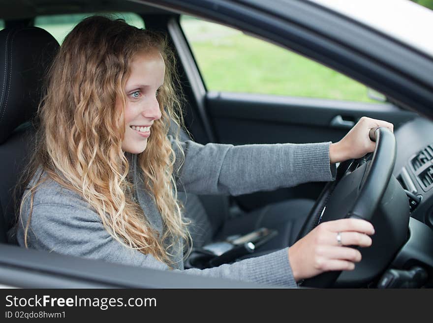 Pretty young woman driving her new car