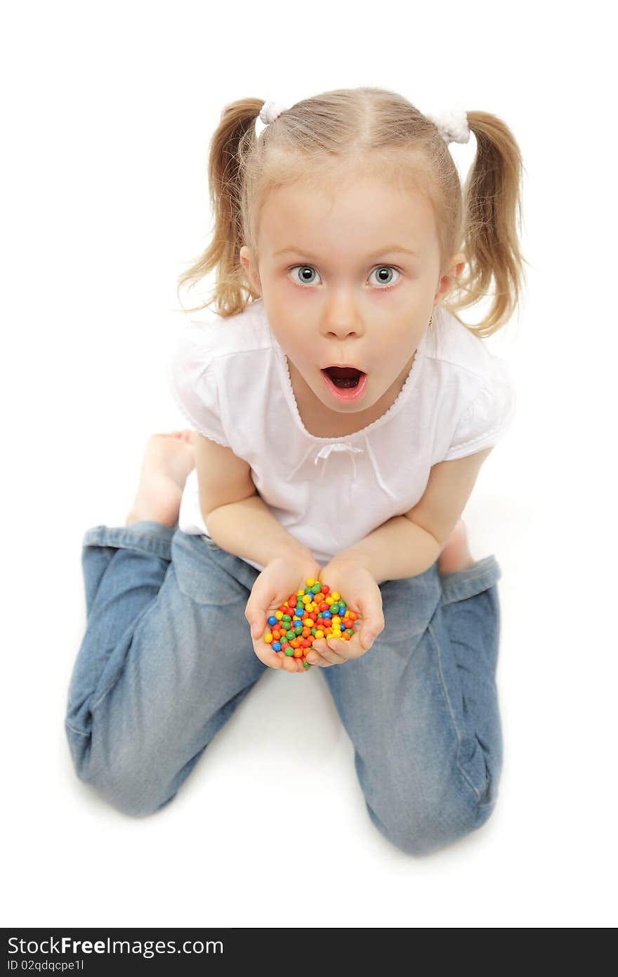 Cute little girl with hands full of candies studio shot on white. Cute little girl with hands full of candies studio shot on white