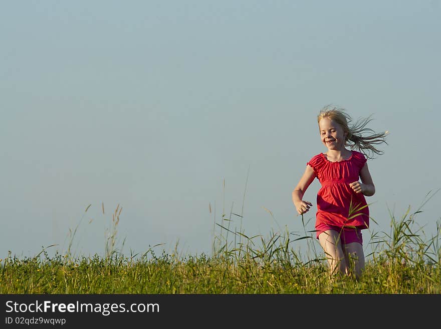 Little Girl Runs On Meadow In Summer