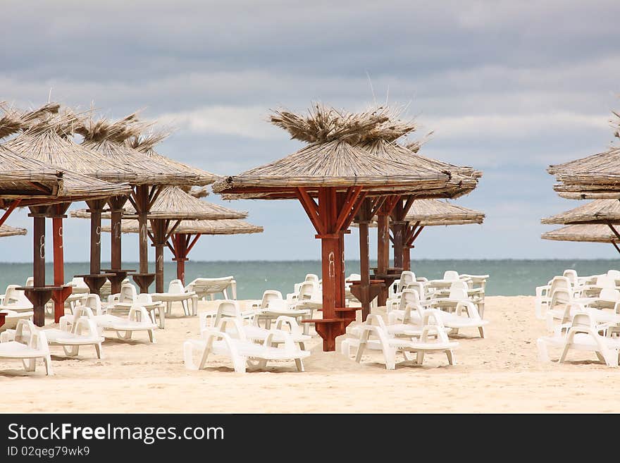 Beach with deckchairs and parasols sea