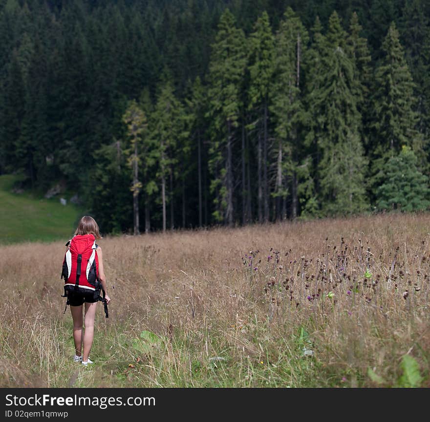 Young woman hiking outdoors (going downhill)