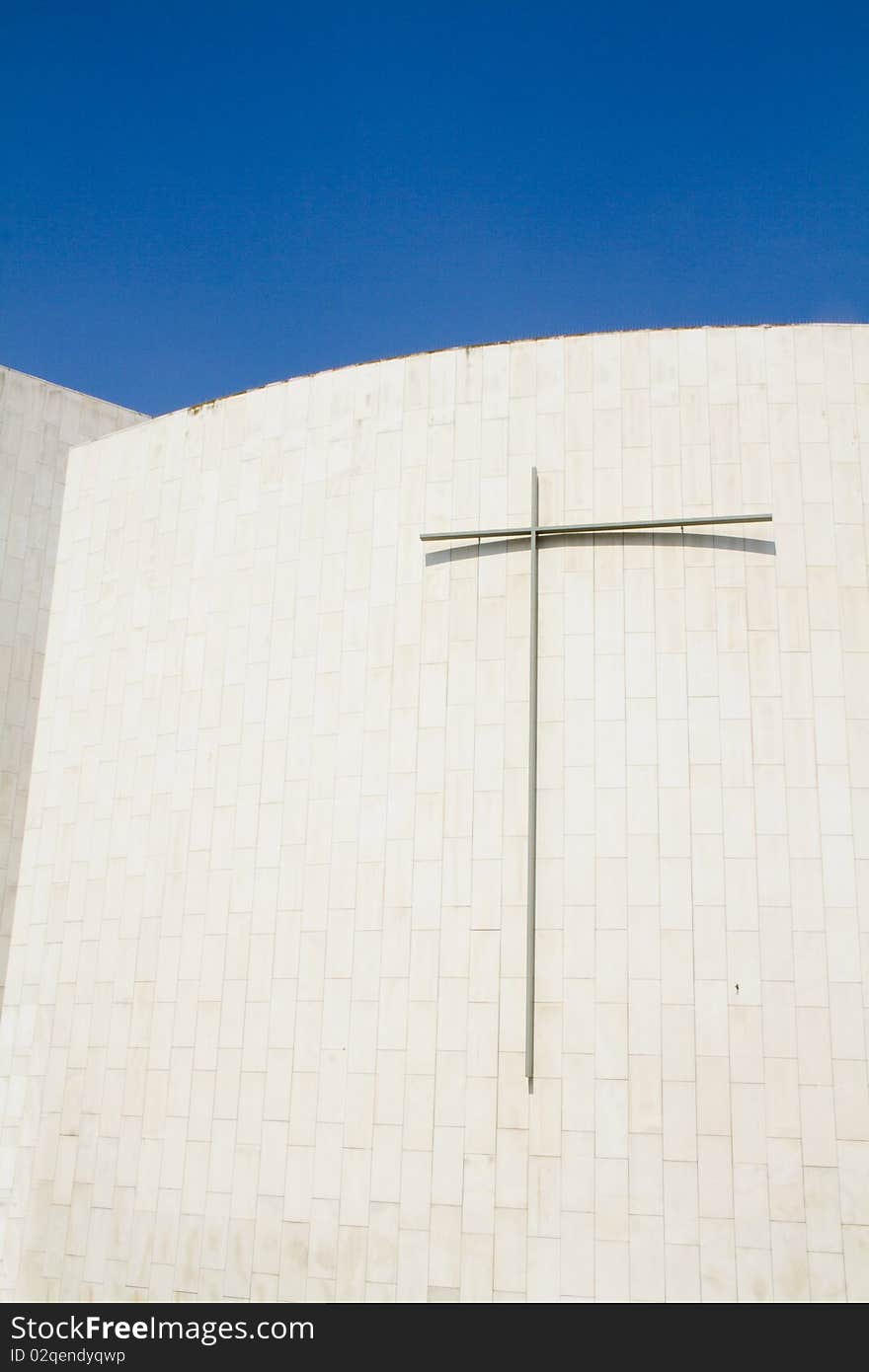 Crucified on a white wall and blue sky