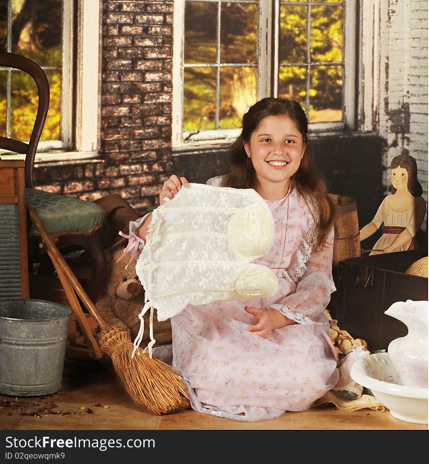 A pretty preteen in an old-time dress from great-grandma's truck, exploring her brick shed. She displays a funny find -- an old brassiere with dangling garter straps. A pretty preteen in an old-time dress from great-grandma's truck, exploring her brick shed. She displays a funny find -- an old brassiere with dangling garter straps.