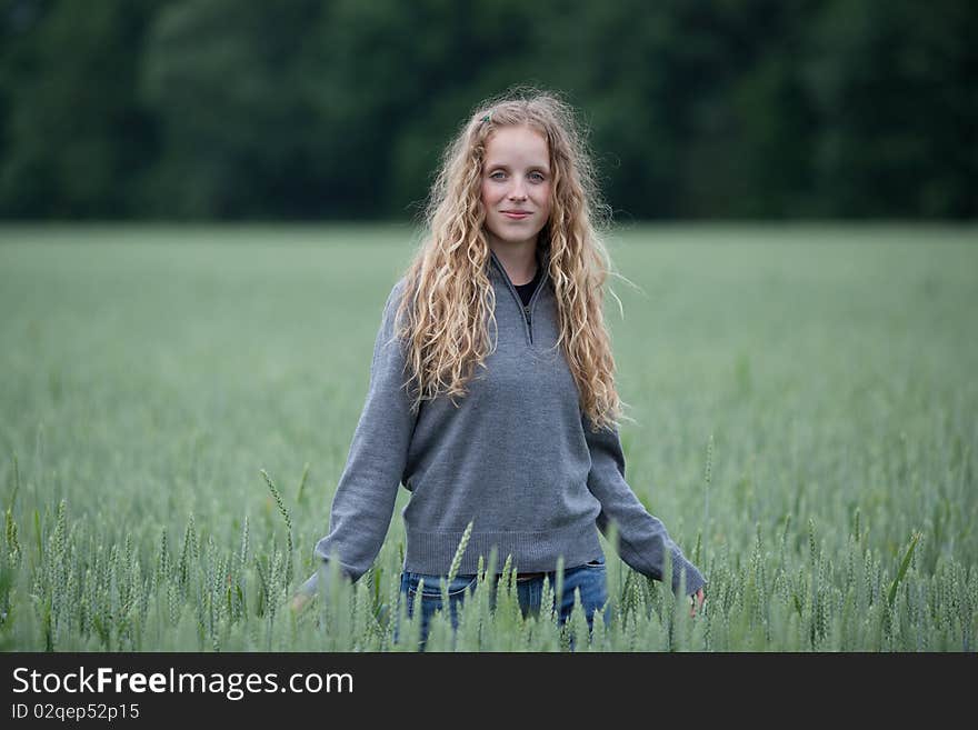 young woman standing in a green field