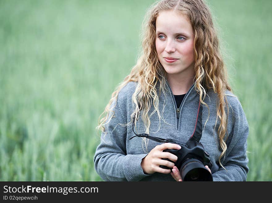 young woman with a DSLR camera outdoors