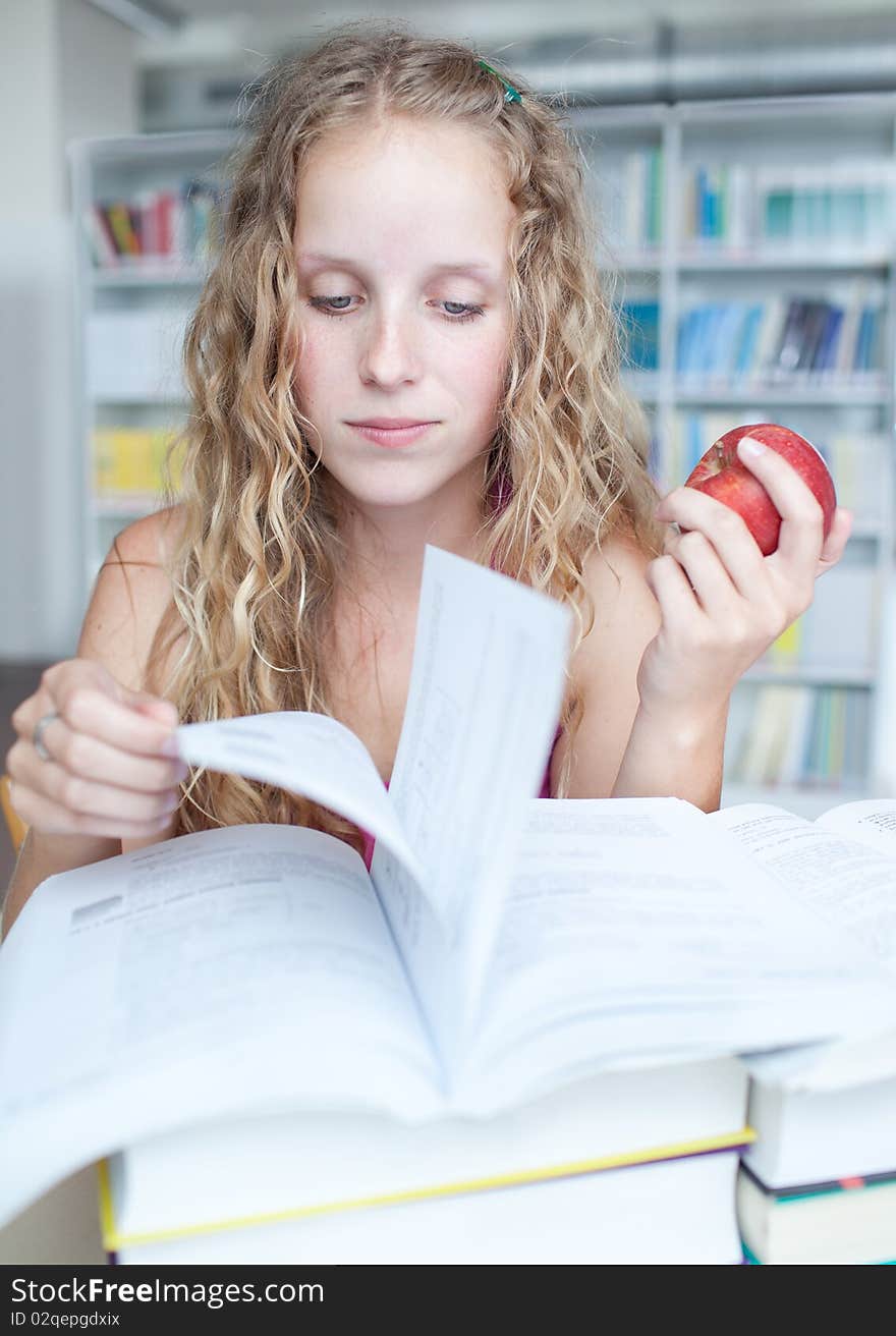 Pretty female college student in a library