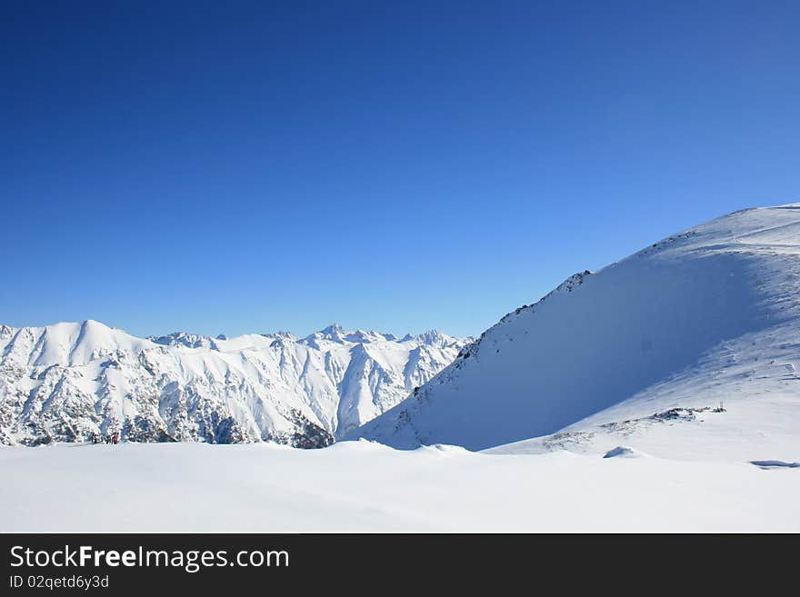 Glacier in the mountains' peak in sunny winter. Place: Russia, Dombai resort. Glacier in the mountains' peak in sunny winter. Place: Russia, Dombai resort.