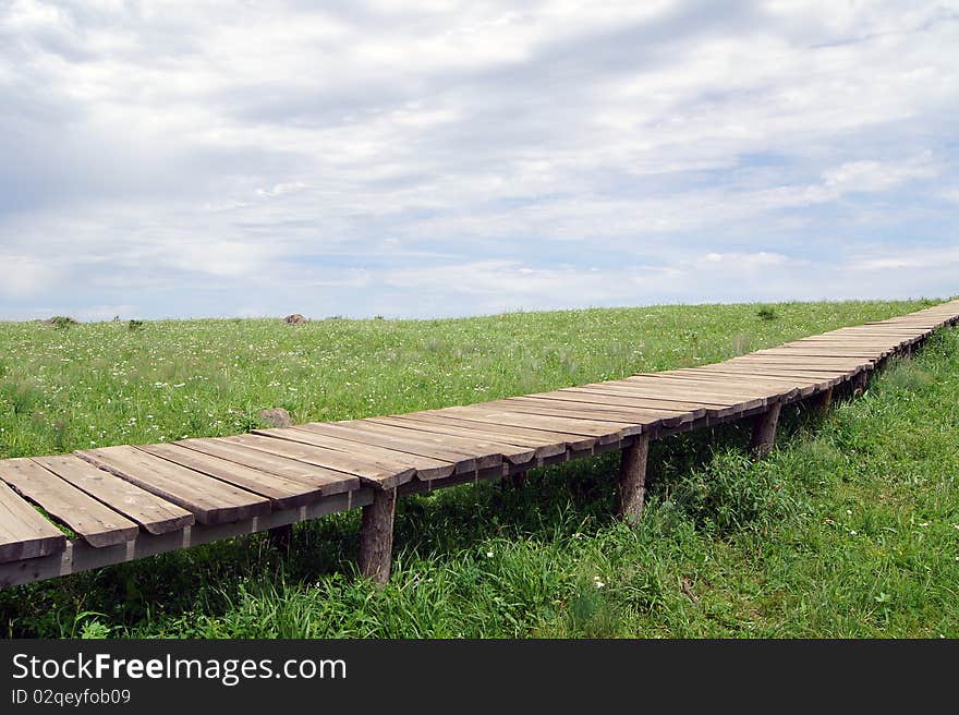 This photo was taken in Beijing, China, Baihua Mountain. Peak meadow paved with wooden paths, paths toward the far, far away is the forest, blue sky and white clouds, the scenery is very beautiful. This photo was taken in Beijing, China, Baihua Mountain. Peak meadow paved with wooden paths, paths toward the far, far away is the forest, blue sky and white clouds, the scenery is very beautiful