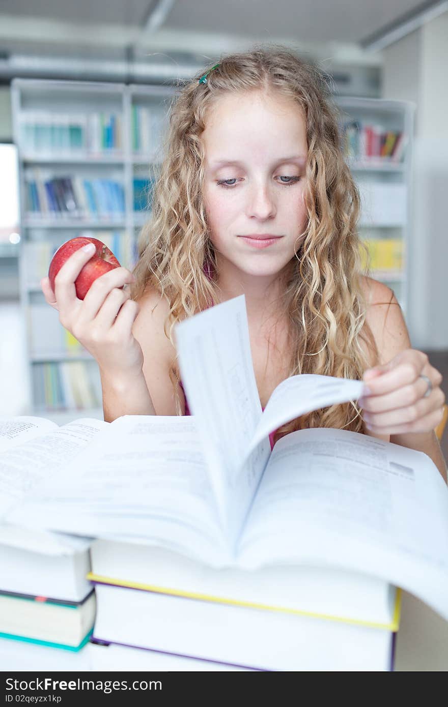 Pretty female college student in a library