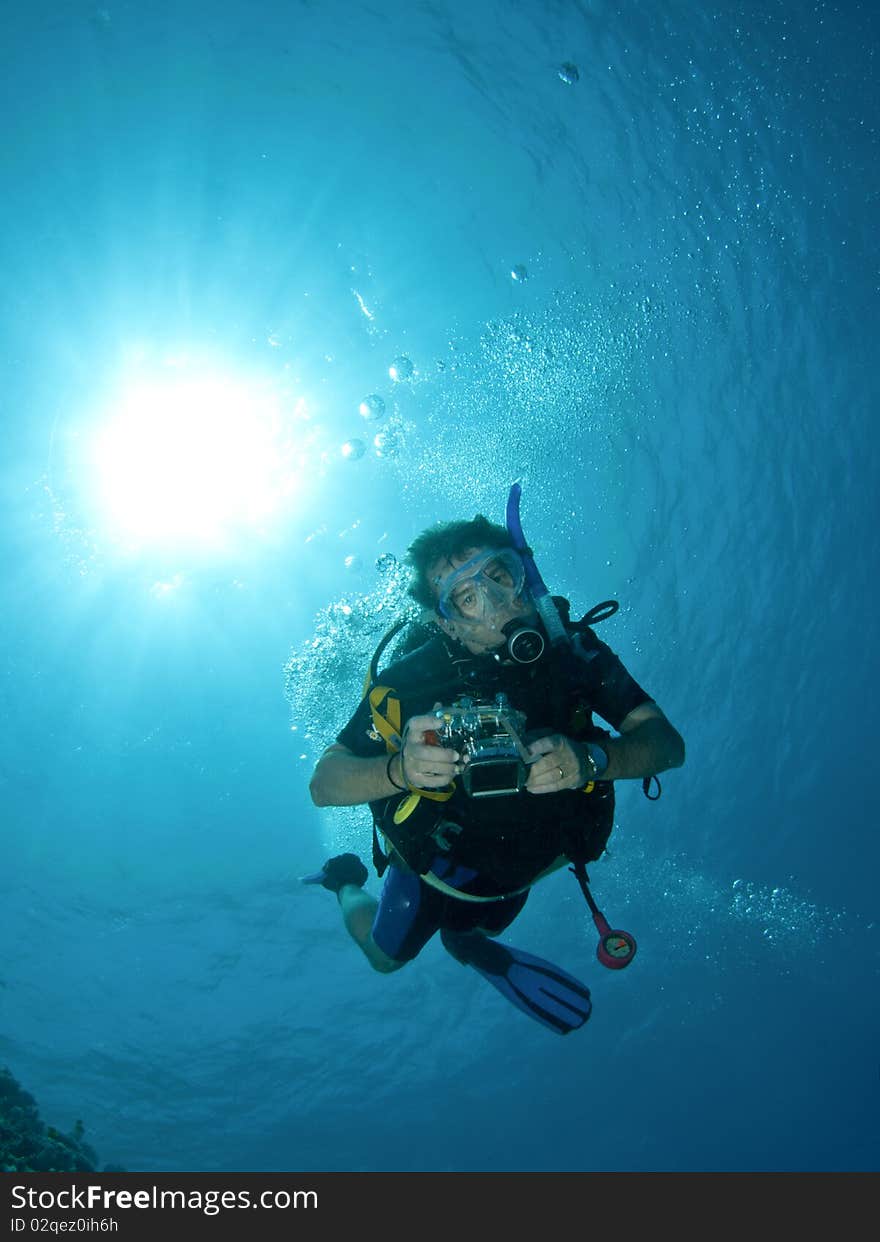 Scuba diver with camera and sun ball