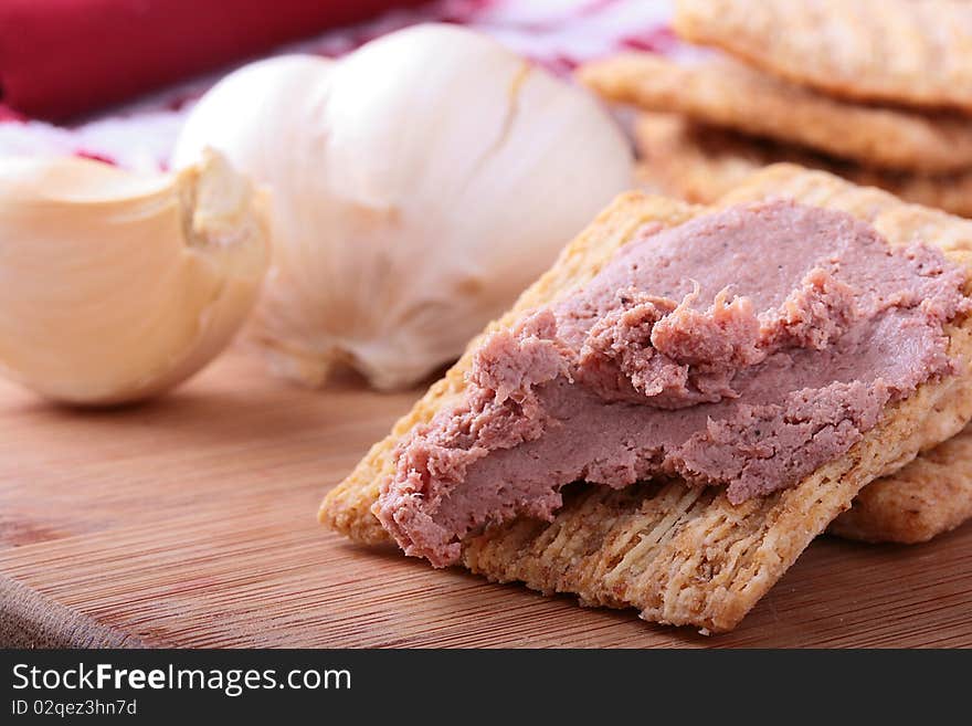 Wheat crackers on a kitchen board with meat paste. Wheat crackers on a kitchen board with meat paste.