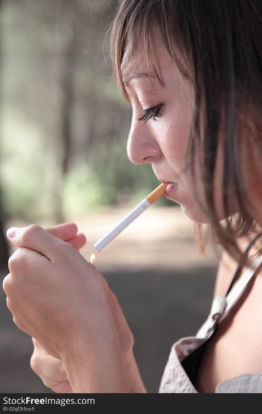 Portrait woman lighting a cigarette