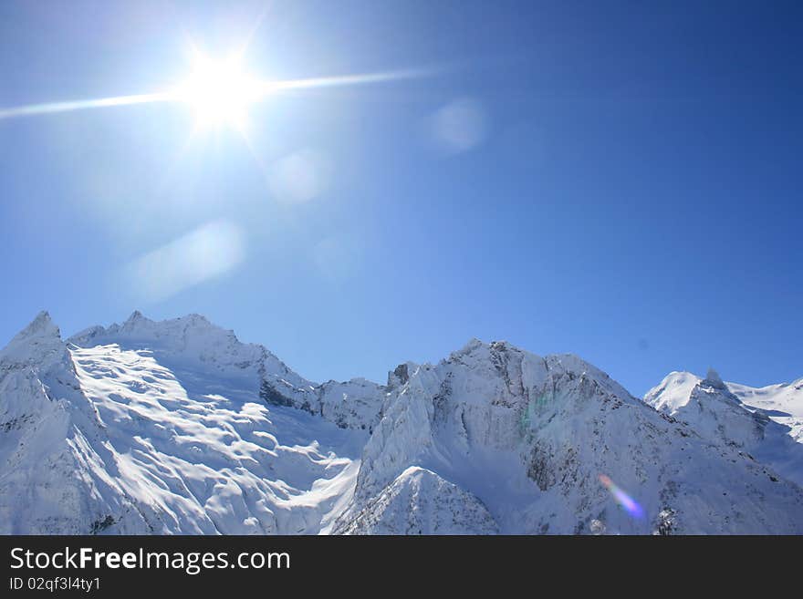 Snowy rocks in sunny weather. Place: Russia, Dombai resort. Snowy rocks in sunny weather. Place: Russia, Dombai resort.