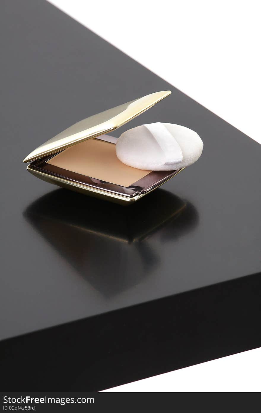 Makeup compact powder on black table isolated on white background