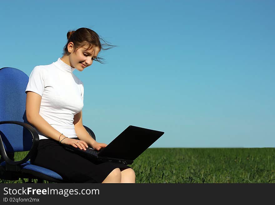 Young businesswoman with laptop in the field. Young businesswoman with laptop in the field