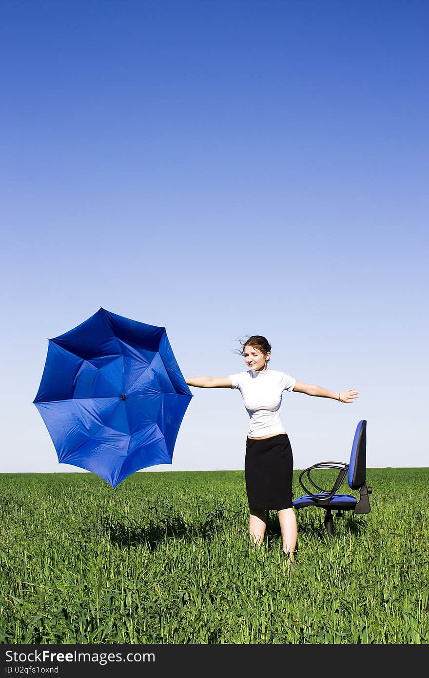 Business women with an umbrella on a grass land