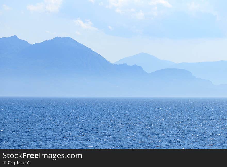 Contour of mountains in the background of a sea scape - photo taken in Greece. Contour of mountains in the background of a sea scape - photo taken in Greece