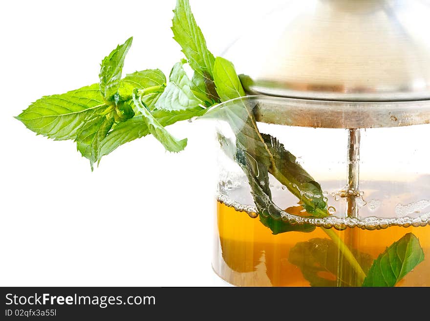 Mint tea in a teapot and a bundle of mint