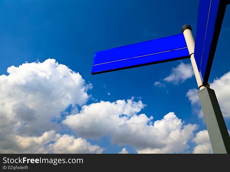 Blue wooden road sign on the blue sky background outdoor.