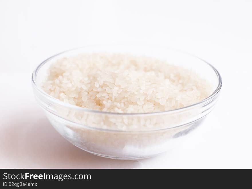 Cup with raw rice on isolated background