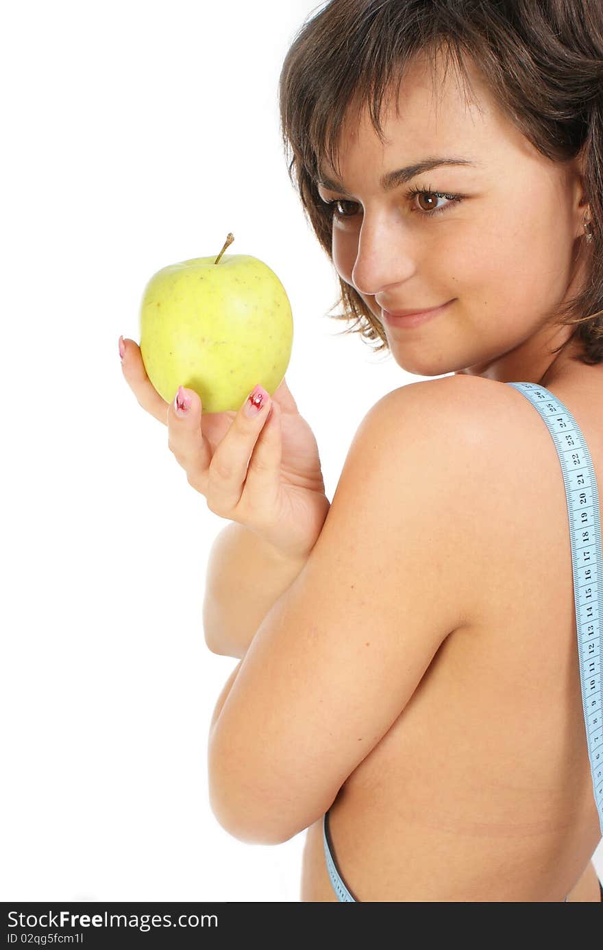 Young girl with measuring tape around slim beautiful waist and holding an apple