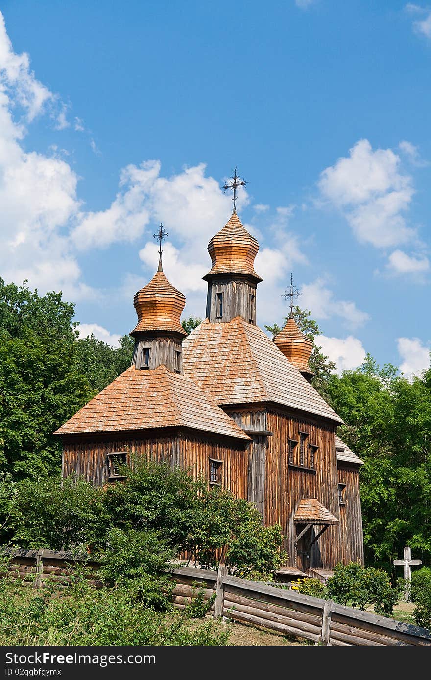 Old wooden church against summer cloudy sky, Ukraine.