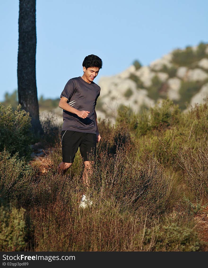 Runner moving through sunlit landscape