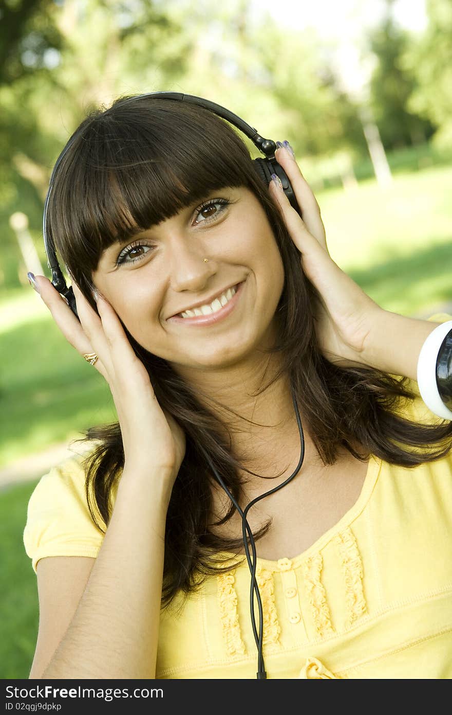 Smiling young woman listening to music at park