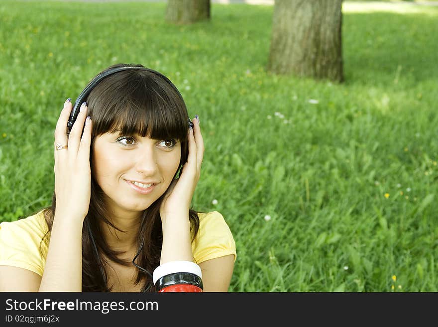 Smiling young woman listening to music at park