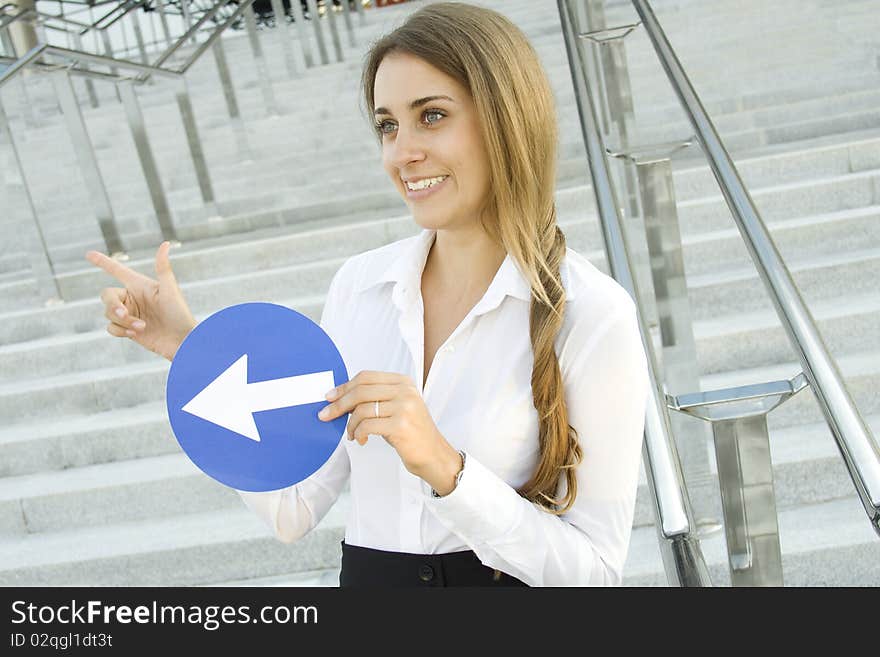 Close-up of a young woman gesturing. In the hands of a traffic sign