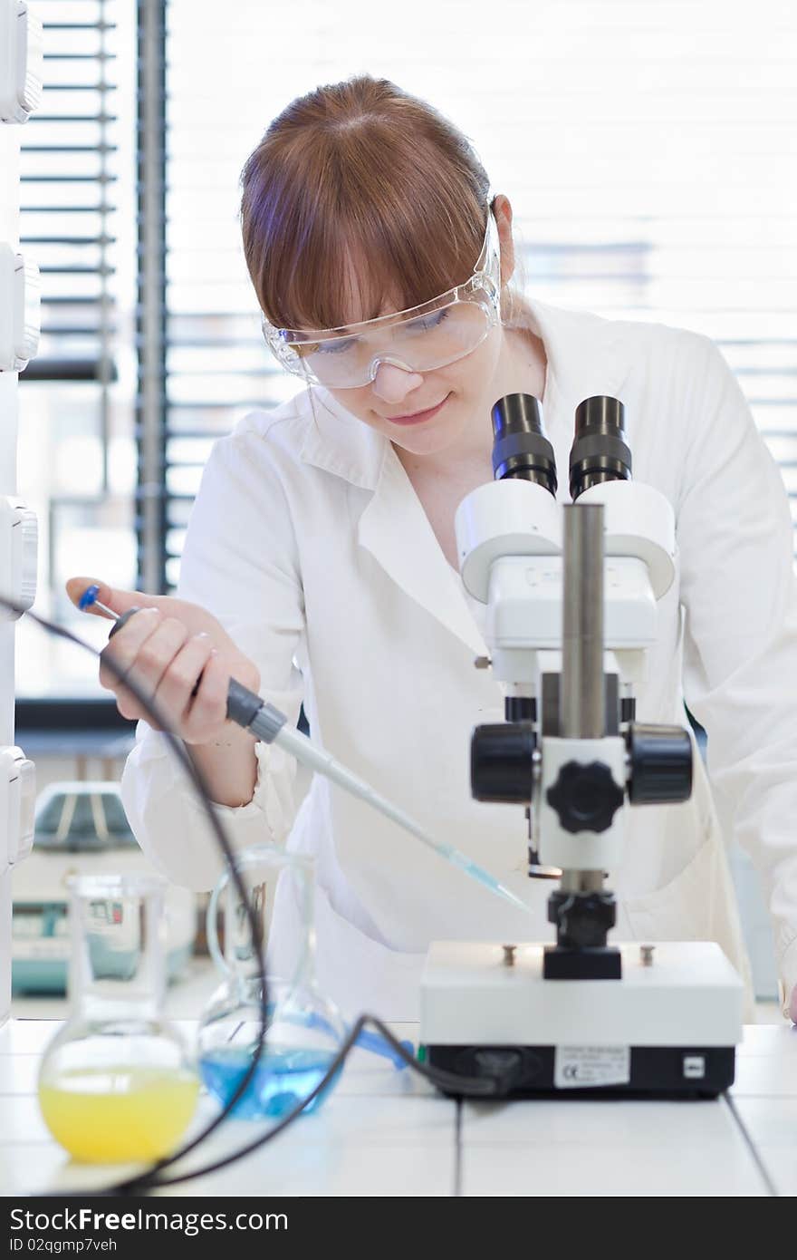 Female researcher using a microscope