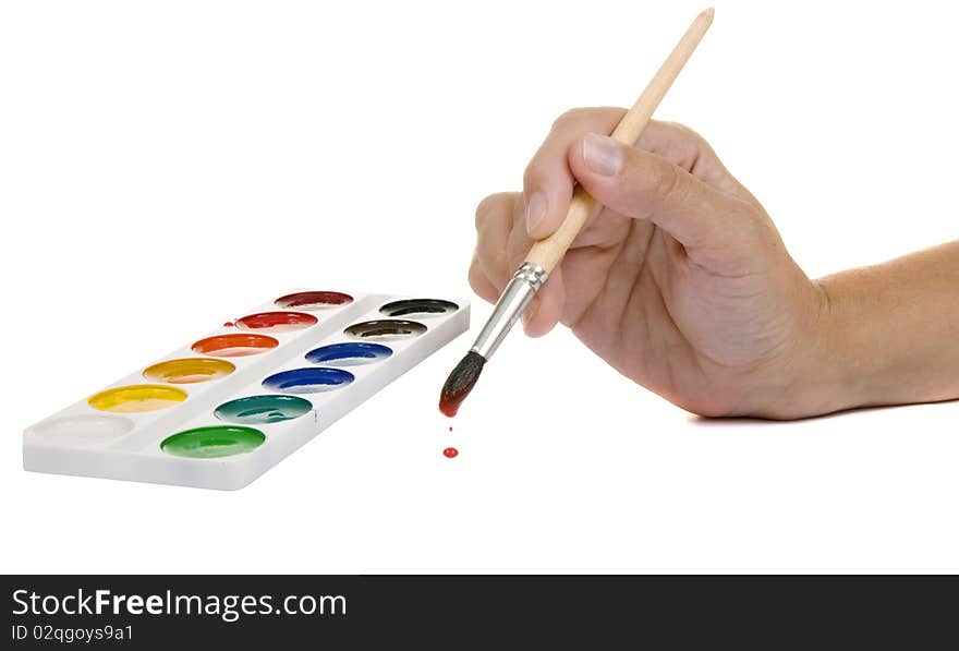 Watercolors and hand with a paintbrush on a white background