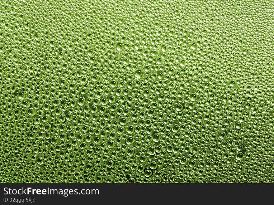 Water drop on glass in Green