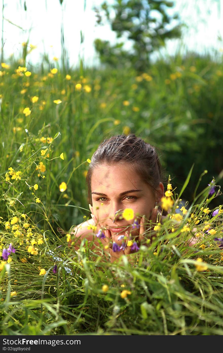 Portrait of a beautiful girl lays on a grass