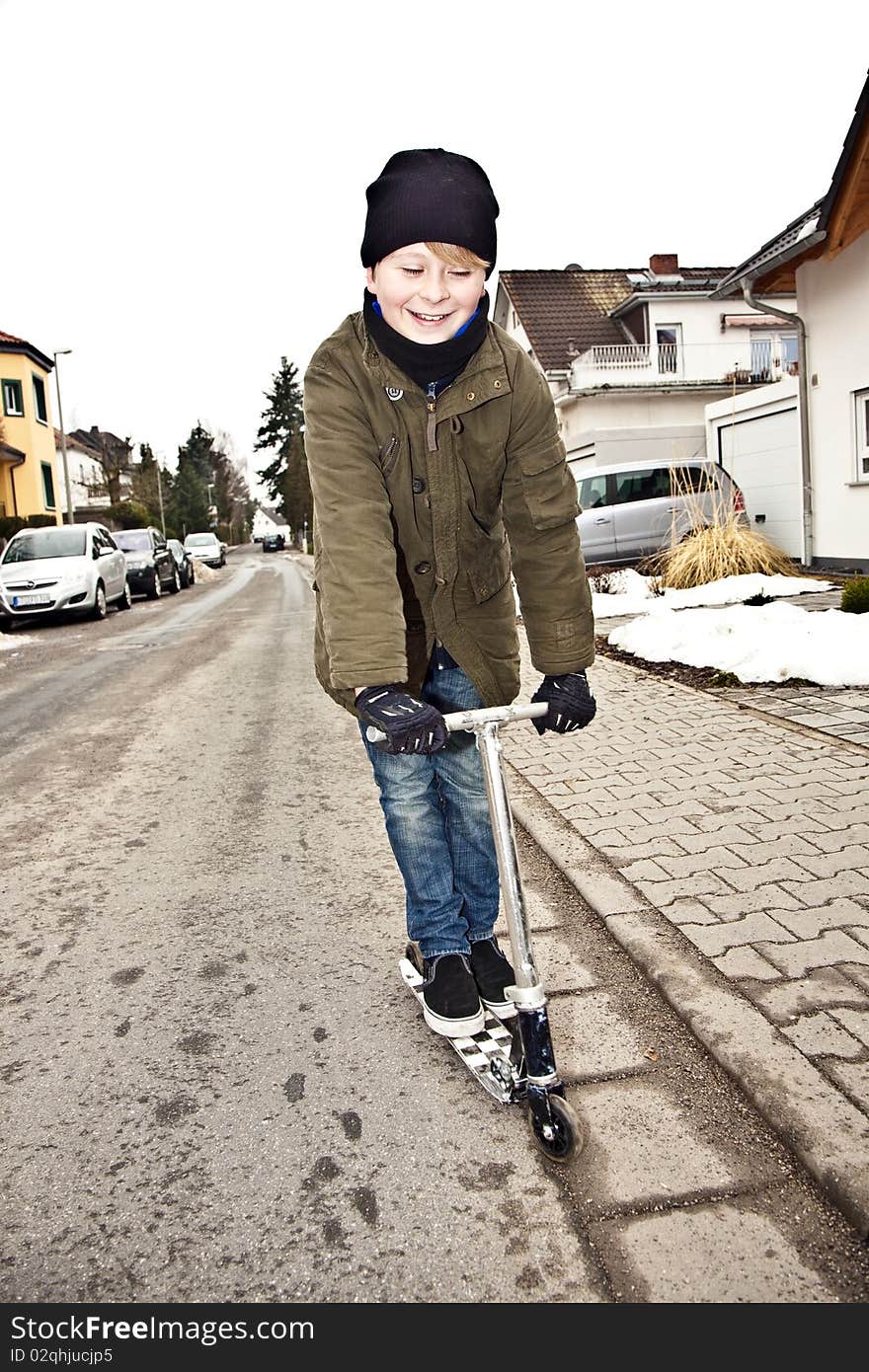 Child with scooter at the street