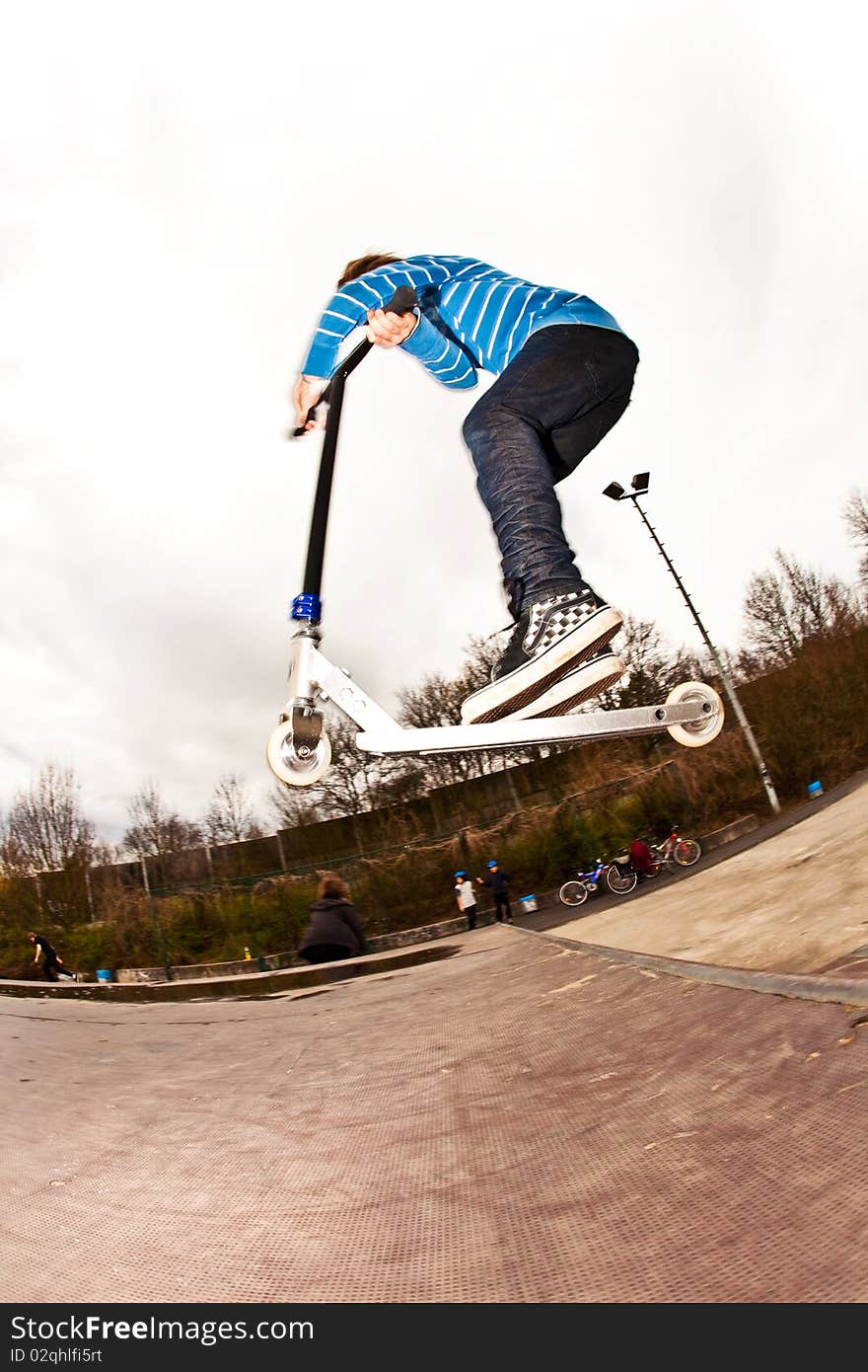 Boy riding a scooter gone airborne on a scooter park. Boy riding a scooter gone airborne on a scooter park