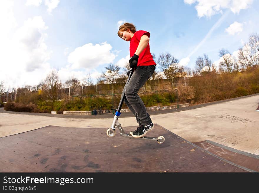 Boy jumping with a scooter over a funbox. Boy jumping with a scooter over a funbox