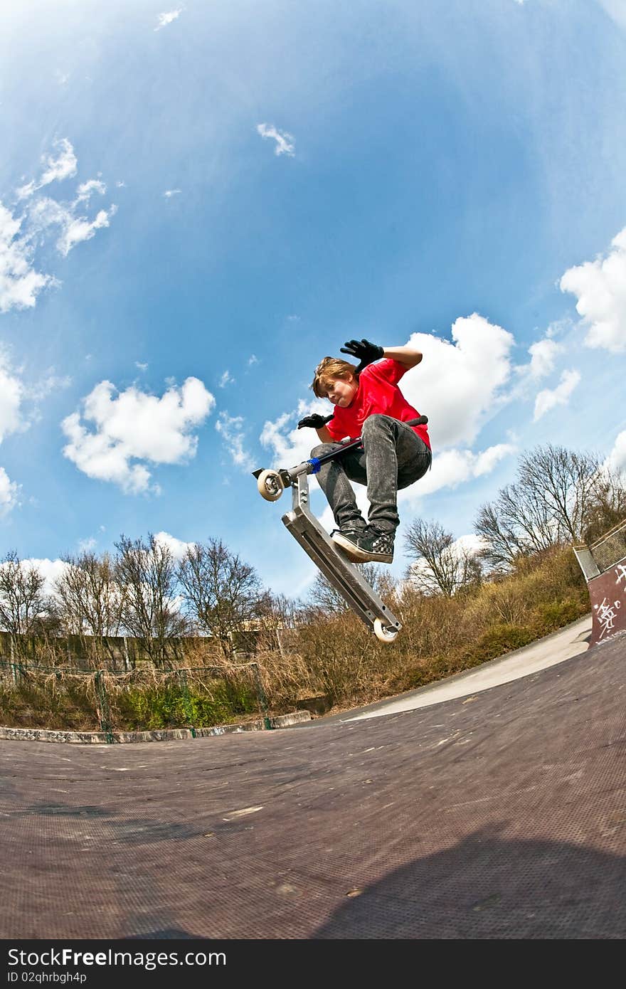 Boy jumping with a scooter over a funbox. Boy jumping with a scooter over a funbox